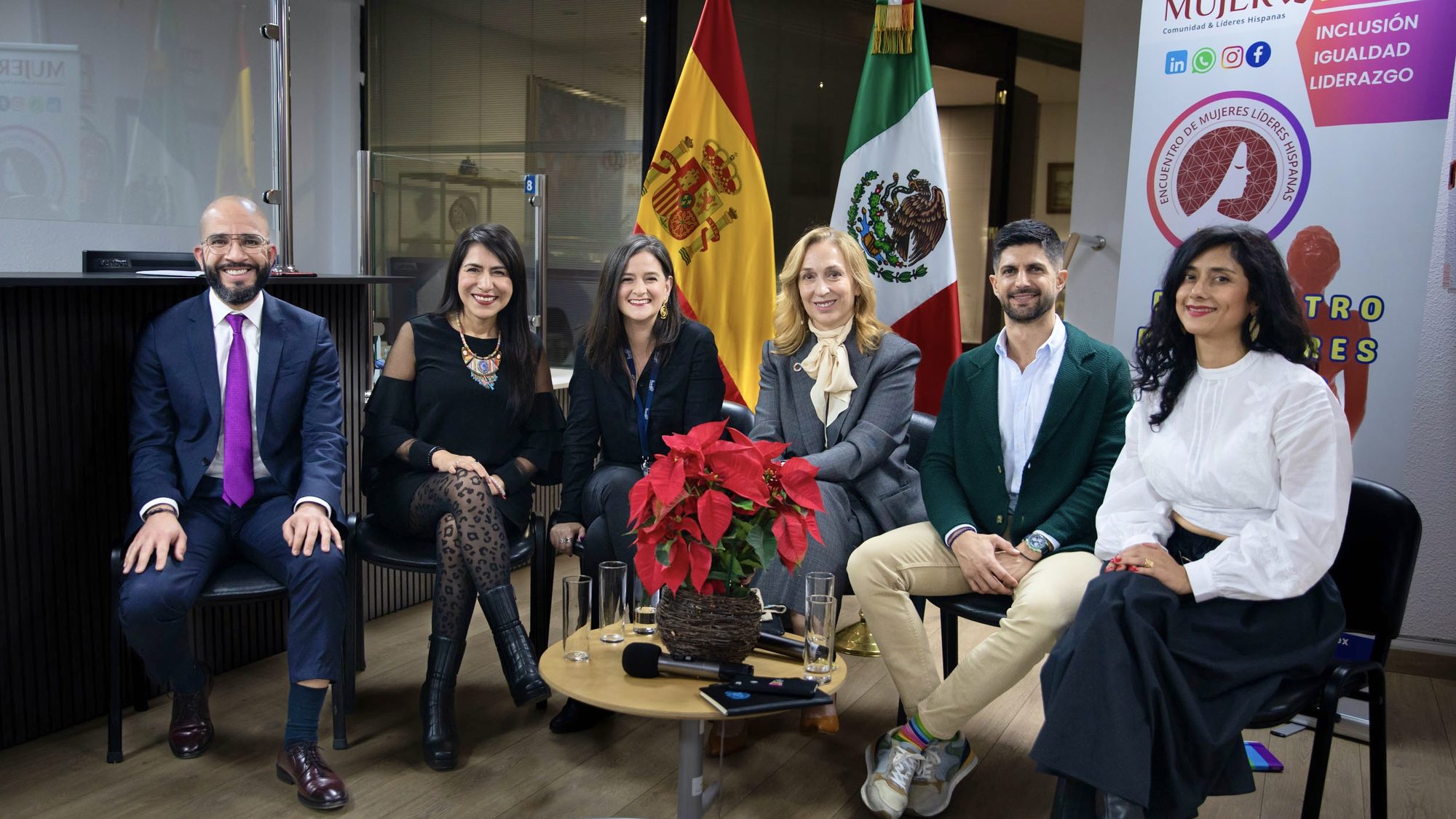 Panel de liderazgo en un encuentro EMLHIS, con las banderas de España y México